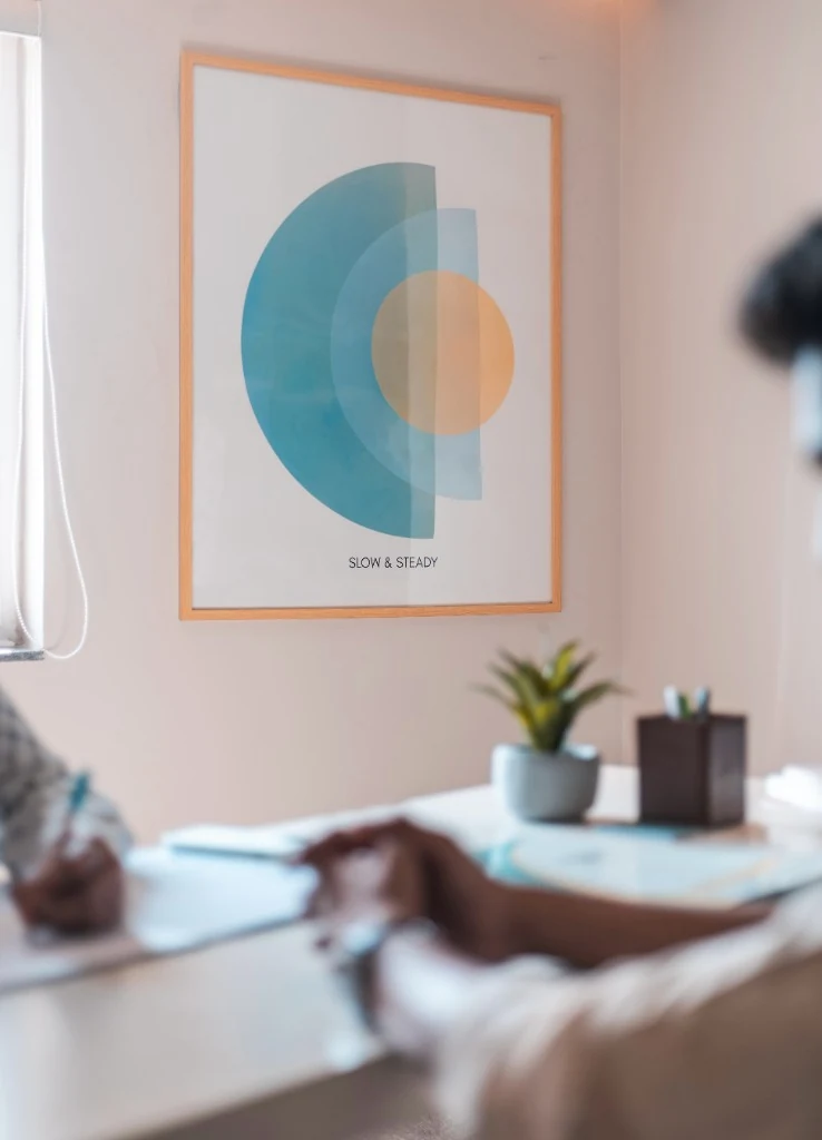 A calming therapy room with a 'Slow & Steady' artwork on the wall